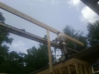 Carpenter setting a ridge beam over a new addition frame — Ice Dam Removal by Roofing Brothers in Finksburg