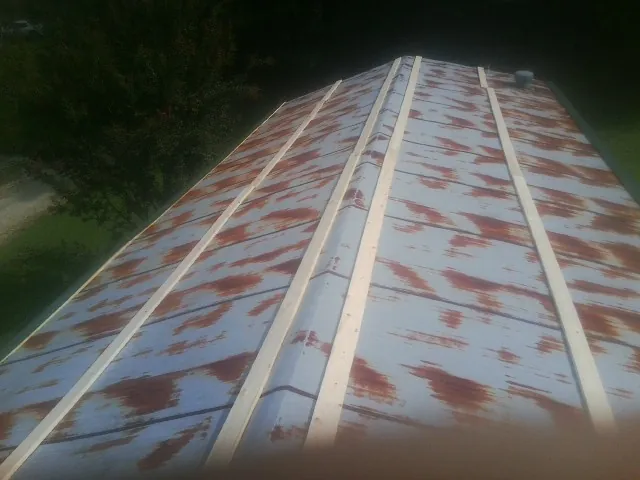 Rusted metal roof panels with new wood purlins before replacement — Storm Damage Roof Repair in Finksburg by Roofing Brothers