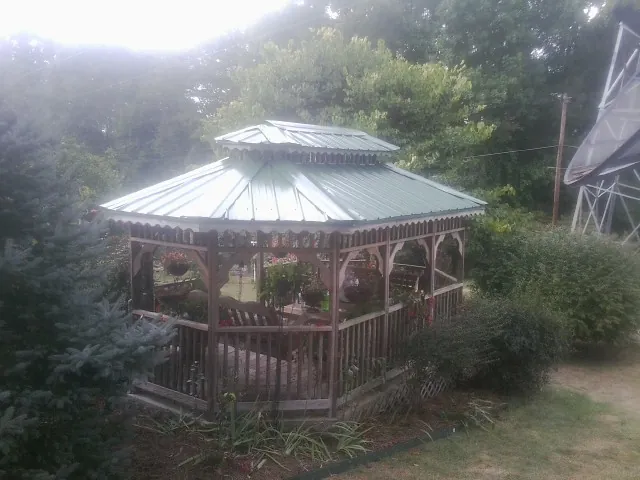 Green metal roof on a backyard gazebo surrounded by garden beds in Finksburg