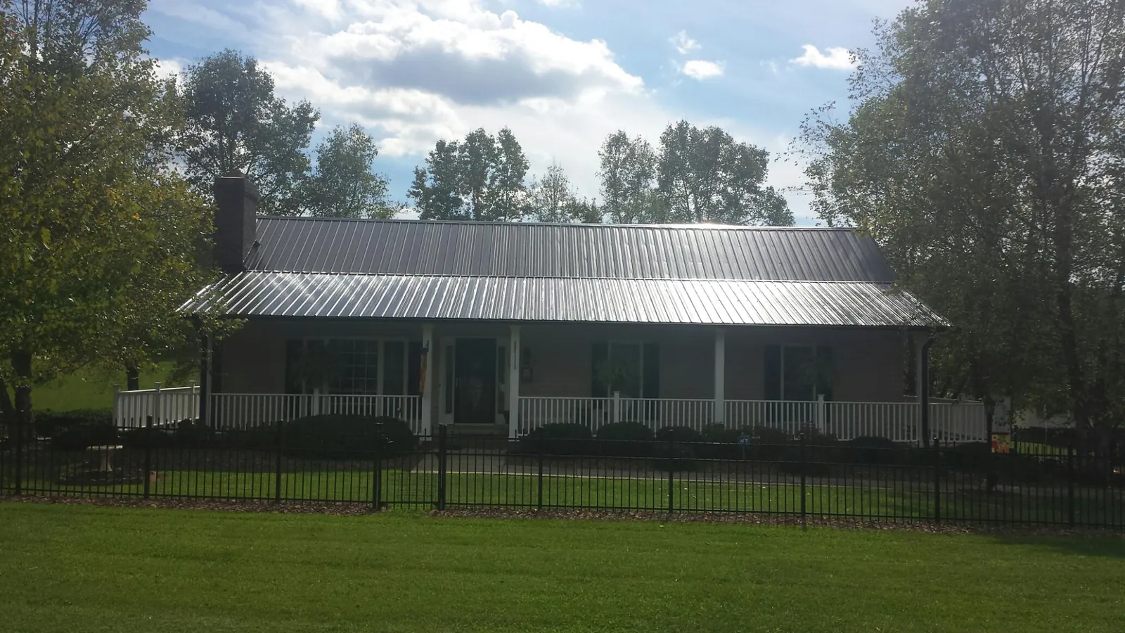 Gray metal roof on a brick ranch with a full width front porch — Gutter Guard Installation work by our crew in Finksburg