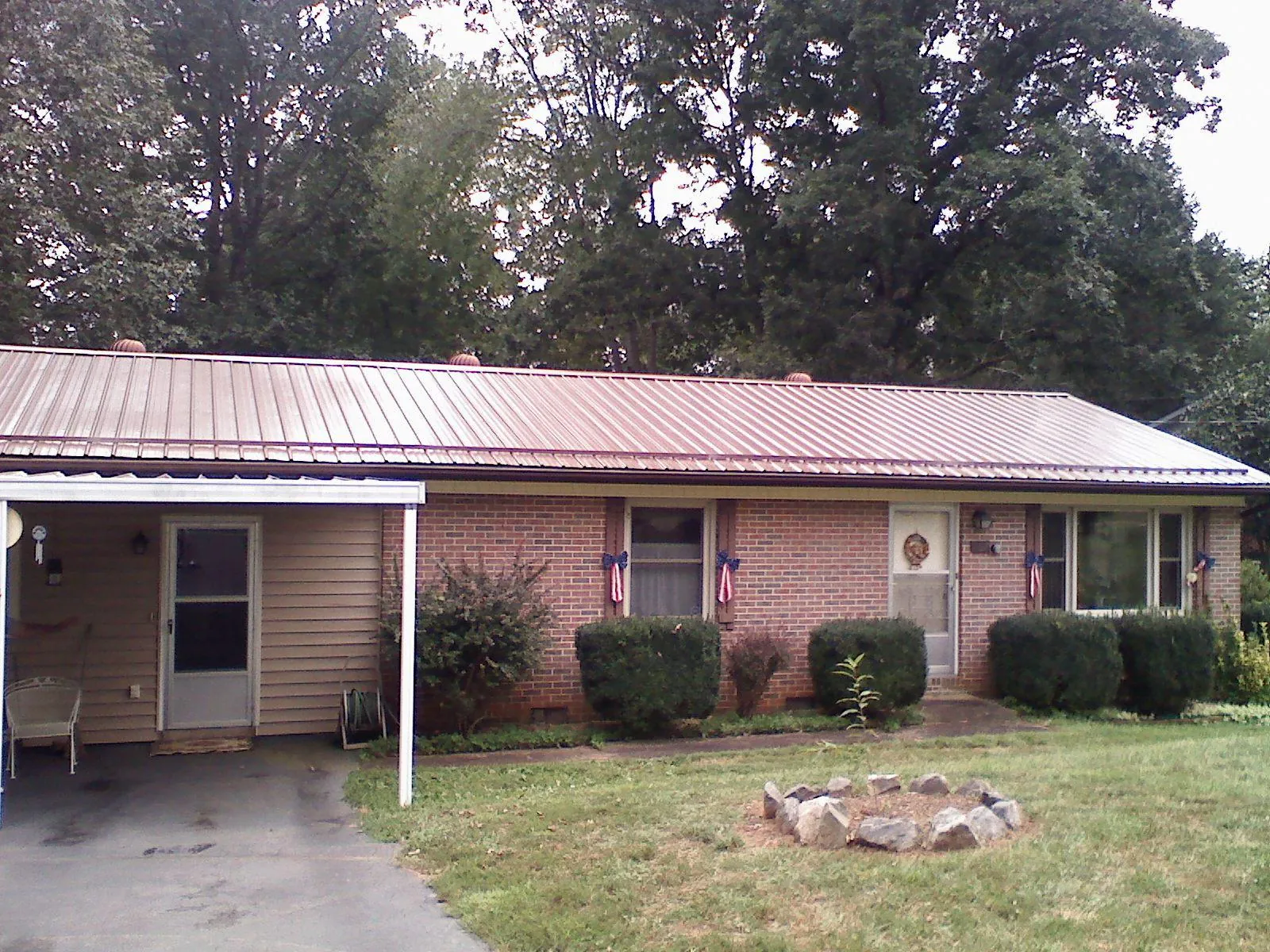 Bronze metal roof and carport on a brick ranch home — Roof Repair work by our crew in Finksburg